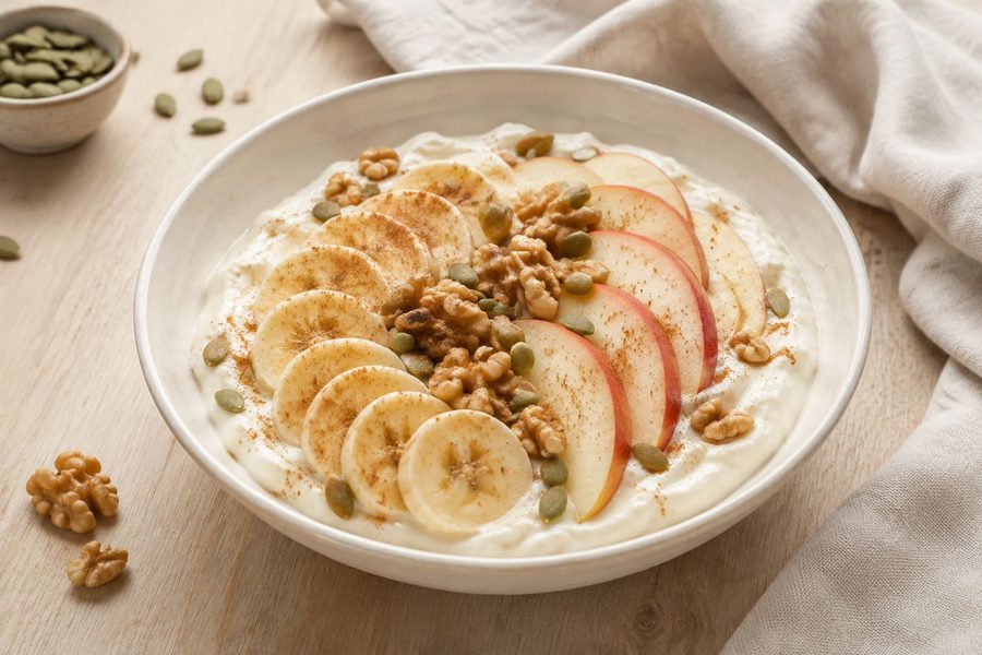 Greek yogurt with banana, apple and walnuts in a bowl
